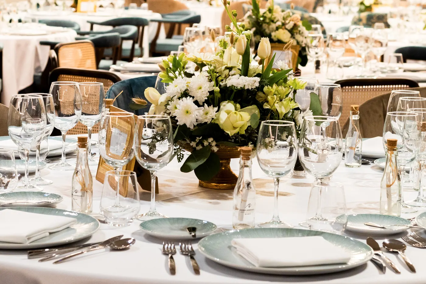 Mesa de restaurante com copos e garrafas de vidro decorados